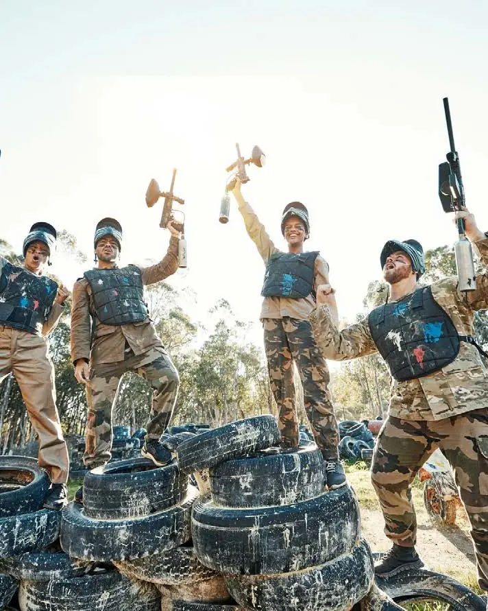 A group taking part in a paintball activity in a wooded area