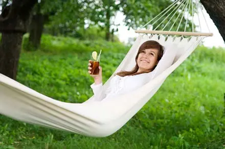 A person relaxing in a hammock among the trees