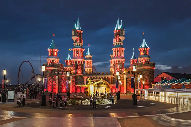 A theme park castle lit up at night